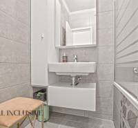 Badezimmer in einer 3-Zimmer-Wohnung mit Badewanne, Waschbecken und Stauraum.