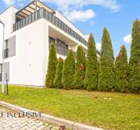 Außenbereich eines modernen Wohnhauses in Dunajská Streda mit privaten Balkonen und Bäumen.