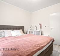 Schlafzimmer in einer 3-Zimmer-Wohnung mit einem bequemen Bett und einem Kinderbett.