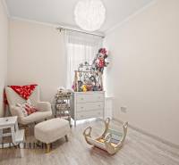 Kinderzimmer in einer 3-Zimmer-Wohnung mit einem bequemen Sessel und Spielzeug, Boden mit Holzdekor.