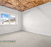 Ein Zimmer mit einem Fenster, einer nackten Decke und Sichtbeton in einem Einfamilienhaus.