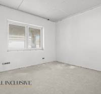 Ein Bauzimmer in einem Einfamilienhaus mit Fenster und unfertigem Boden, bereit zur Fertigstellung.