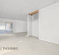 Ein geräumiger Raum in einem Einfamilienhaus mit unfertigem Boden und einem großen Fenster.