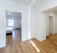 2-Zimmer-Wohnung mit Holzboden und Schlafzimmer, helles Interieur.