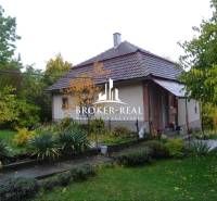 Ein Einfamilienhaus in Fony mit einem großen Garten, umgeben von Grün und Bäumen.