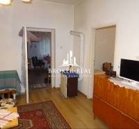 Wohnzimmer in einem Einfamilienhaus mit Teppich und Boden in Holzoptik.