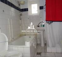 Badezimmer mit Badewanne und weißen Fliesen in einem Einfamilienhaus.