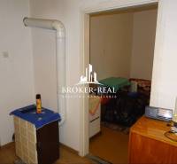 Innenraum eines Einfamilienhauses mit Heizkörper, Möbeln und einem Boden in Holzoptik.