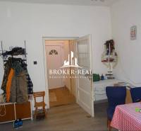 Innenraum eines Einfamilienhauses mit Holzboden, Esstisch und Kleiderständer.