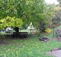 Garten bei einem Einfamilienhaus in Fony, mit Sitzgelegenheiten aus Paletten und einer Feuerstelle.