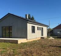 Ein Einfamilienhaus in Tesárske Mlyňany mit einer unverputzten Fassade und einer Betonterrasse.