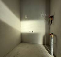 Ein leerer Raum mit Betonboden und Installationen in einem Einfamilienhaus.