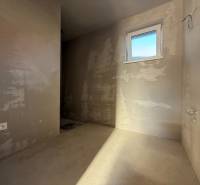 Leere Wände, Fenster und Steckdose im Inneren eines Einfamilienhauses; bereit für weitere Anpassungen.