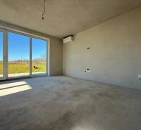 Ein geräumiges Zimmer in einem Einfamilienhaus mit großen Fenstern und Blick auf den Garten.