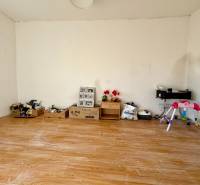 Ein Zimmer in einem Einfamilienhaus mit Wänden voller Spielzeug und einem Boden mit Holzdekor.