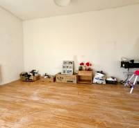 Ein Zimmer in einem Einfamilienhaus mit einem Holzboden und verschiedenen Gegenständen an der Wand.