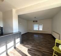 Innenraum eines Einfamilienhauses mit geräumigem Zimmer, Holzboden und Essecke.