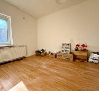 Ein Zimmer in einem Einfamilienhaus mit einem Holzboden und Möbeln.