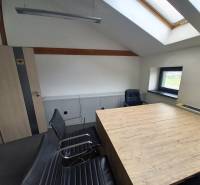 Innenraum eines Büros mit Konferenztisch und Stühlen, Boden mit Holzdekor.