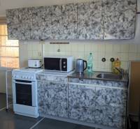 Küche mit Fliesen, Herd und Kamin in einem Einfamilienhaus, Boden mit Holzdekor.