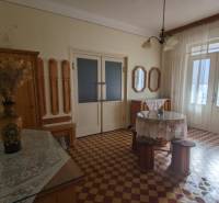 Innenraum eines Einfamilienhauses mit farbigen Fliesen, einer Blumenvase und Vorhängen.