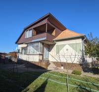 Ein Einfamilienhaus in Vráble mit Dachboden, kleiner Terrasse und Garten mit Obstbäumen.