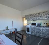 Eine Küche in einem Einfamilienhaus mit einem Ofen und einer Küchenzeile, Boden mit Holzdekor.