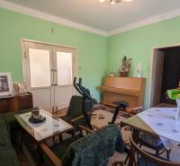 Wohnzimmer in einem Einfamilienhaus mit Möbeln, Fitnessgeräten und grünen Wänden.