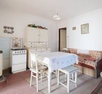 Esszimmer mit Gasherd, Tisch und Sofa in einem Einfamilienhaus, Boden mit Holzdekor.