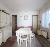 Küche in einem Einfamilienhaus mit Retro-Möbeln, Tisch und Spüle, Boden mit Holzdekor.