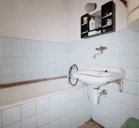 Badezimmer mit Badewanne, Waschbecken und blauen Fliesen in einem Einfamilienhaus.