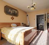 Schlafzimmer in einem Einfamilienhaus mit Holzmöbeln, einem Bild und einem Kronleuchter.