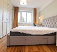 Helles Schlafzimmer mit großem Bett, Einbauschrank und Holzboden in einer 3-Zimmer-Wohnung.
