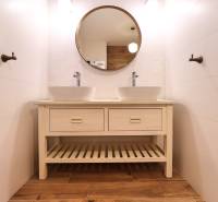 Badezimmer in einer 3-Zimmer-Wohnung mit Doppelwaschbecken und Boden mit Holzdekor.