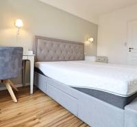 Schlafzimmer in einer 3-Zimmer-Wohnung mit einem komfortablen Bett und einem Boden in Holzoptik.