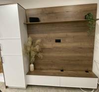 In der 1-Zimmer-Wohnung gibt es eine Schrankwand mit Holzdekor und Blumen in einer Vase.