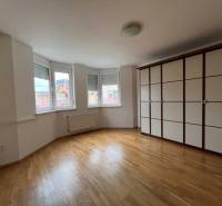 Geräumiges Zimmer mit Holzboden und Einbauschrank in einer 3-Zimmer-Wohnung.