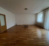 Geräumiges Wohnzimmer mit Holzboden und Fenstern in einer 3-Zimmer-Wohnung.