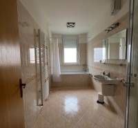 Badezimmer in einer 3-Zimmer-Wohnung mit Badewanne, Glasdusche und hellen Fliesen.