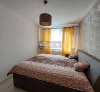 Schlafzimmer mit gemusterten Tapeten und Vorhängen in einer 3-Zimmer-Wohnung.