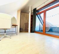 Arbeitszimmer in einer 2-Zimmer-Wohnung mit Holzboden und Balkontüren.