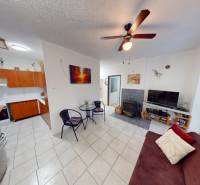 Wohnzimmer und Küche in einer 3-Zimmer-Wohnung mit Fliesen und einem Kaminofen.