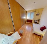 Schlafzimmer in einer 3-Zimmer-Wohnung mit großem Einbauschrank und Boden in Holzoptik.