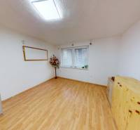 Ein Zimmer in einer 3-Zimmer-Wohnung mit einem Holzboden und einfacher Einrichtung.