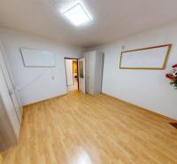 Ein Zimmer in einer 3-Zimmer-Wohnung mit Schränken, Blumendekoration und einem Boden in Holzoptik.