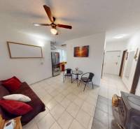 Wohnzimmer in einer 3-Zimmer-Wohnung mit Fliesenboden, ausziehbarem Sofa und Deckenventilator.