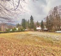 Herbstpanorama von Baugrundstücken in Makov, Čierne, umgeben von Bäumen und einer Straße mit einem Auto.