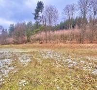 Verschneite Wohnbaugrundstücke in Makov auf Čierne, umgeben von Bäumen und Gras.