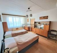 Schlafzimmer in einer 3-Zimmer-Wohnung mit zwei Betten und einem Boden in Holzoptik.