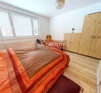 Schlafzimmer in einer 2-Zimmer-Wohnung mit Bett, Schrank und Boden in Holzoptik.